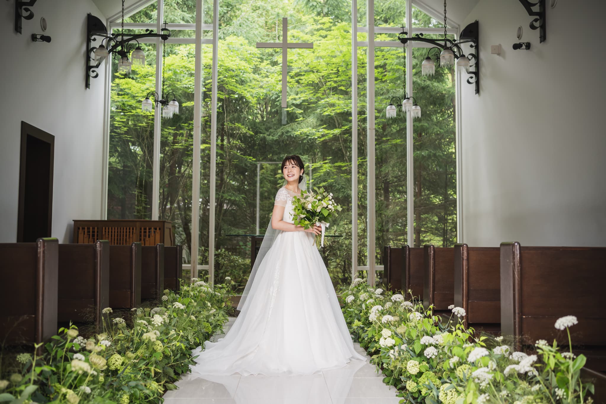 旧軽井沢の大自然に包まれた森の中で挙げる、石とガラスを組み合わせた「森のチャペル軽井沢礼拝堂」。青空をバックにした白いチャペルが、神秘的で荘厳な印象を与えます。